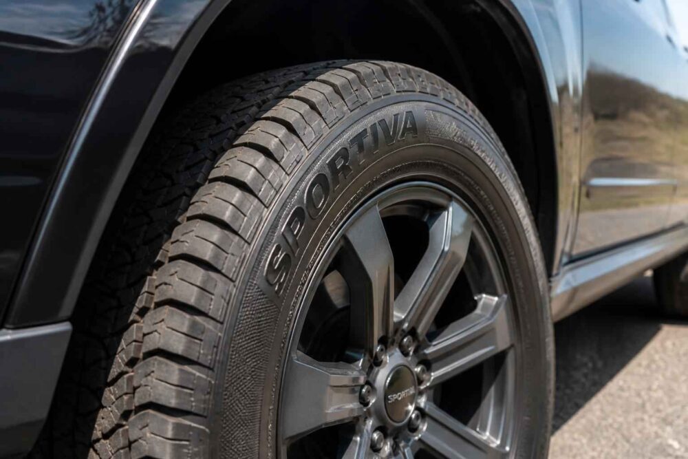 Zbliżenie opony Sportiva i aluminiowej felgi zamontowanych w czarnym SUV-ie